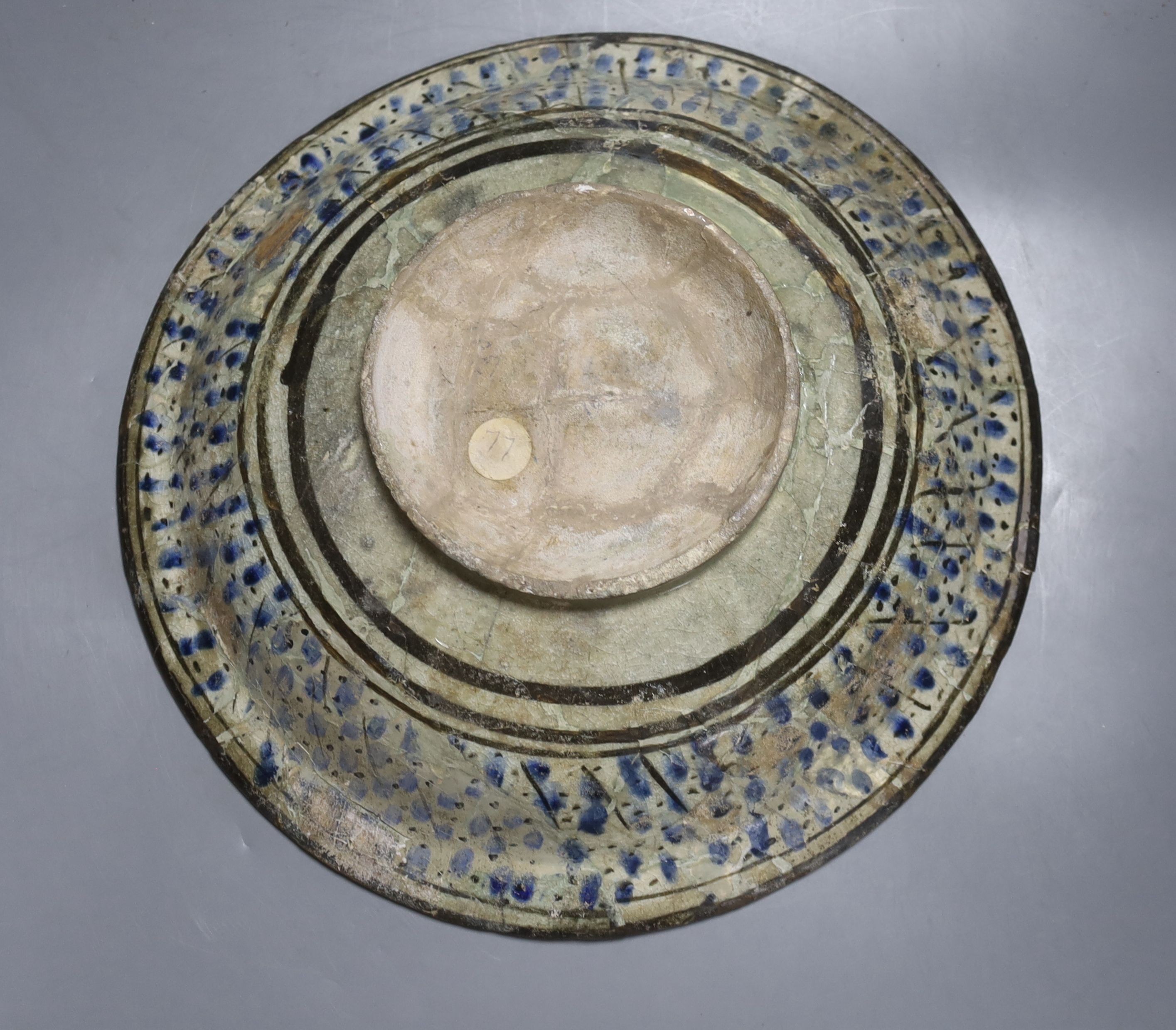 A Kashan Persian pottery dish, 13th-14th century, restored, 35 cms diameter.